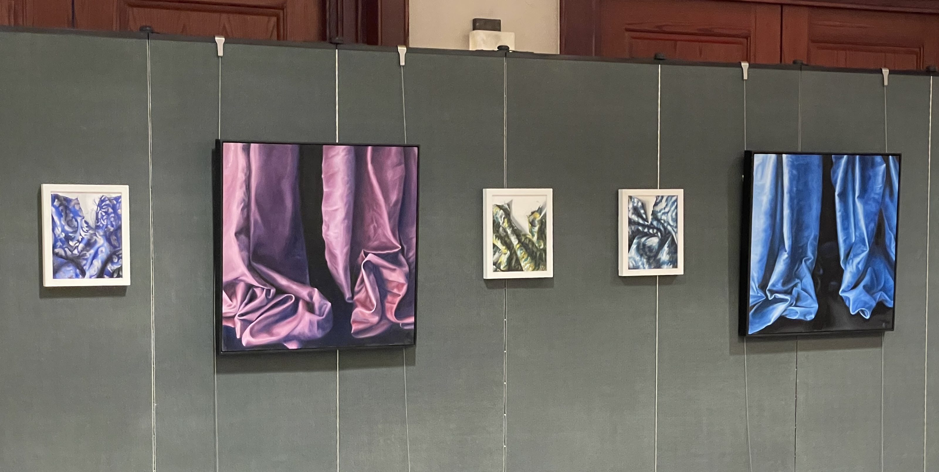 Artworks by Aimee West Cardoso displayed on dividers using picture rail molding hangers