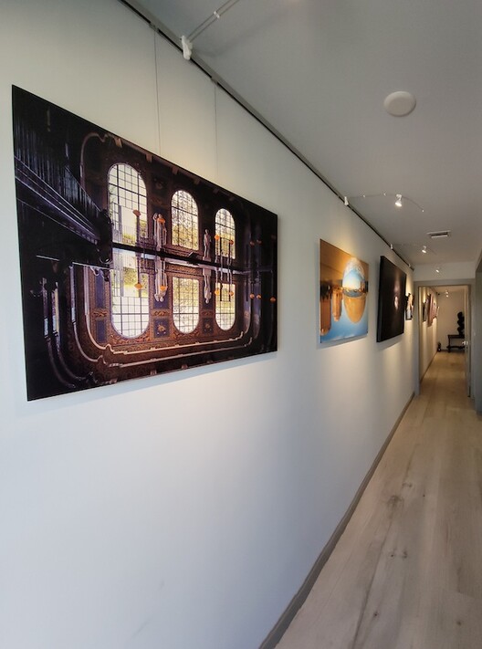 Office art display mounted on picture hanging system in corridor