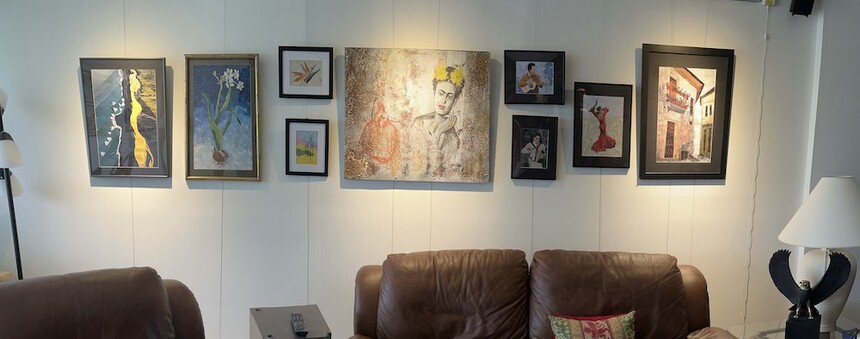 Panoramic shot of art hung on wall using picture hanging system