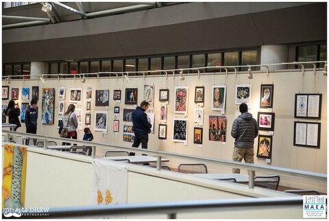 Visitors viewing art display hung using picture hanging system