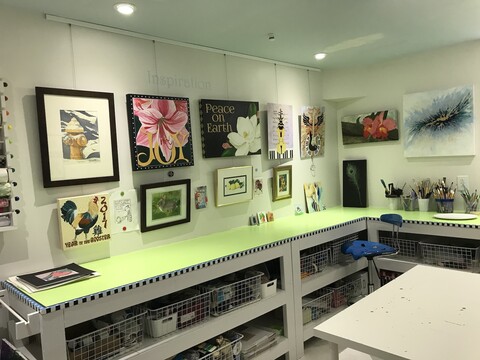 Art studio equipped with picture hanging system above workbench